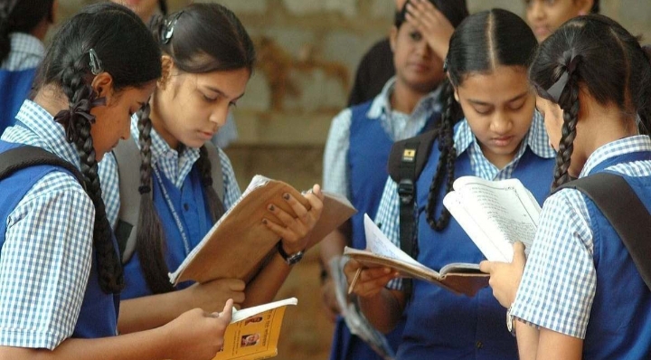 Students reading books together outdoors